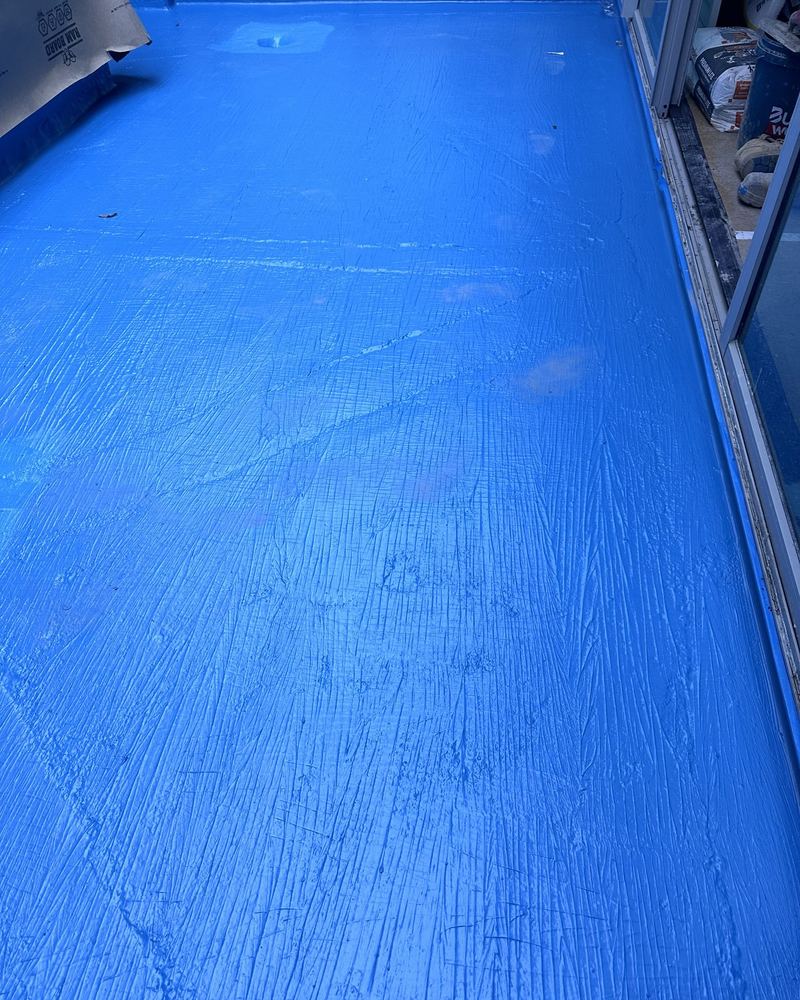 Blue waterproofing membrane applied across a balcony