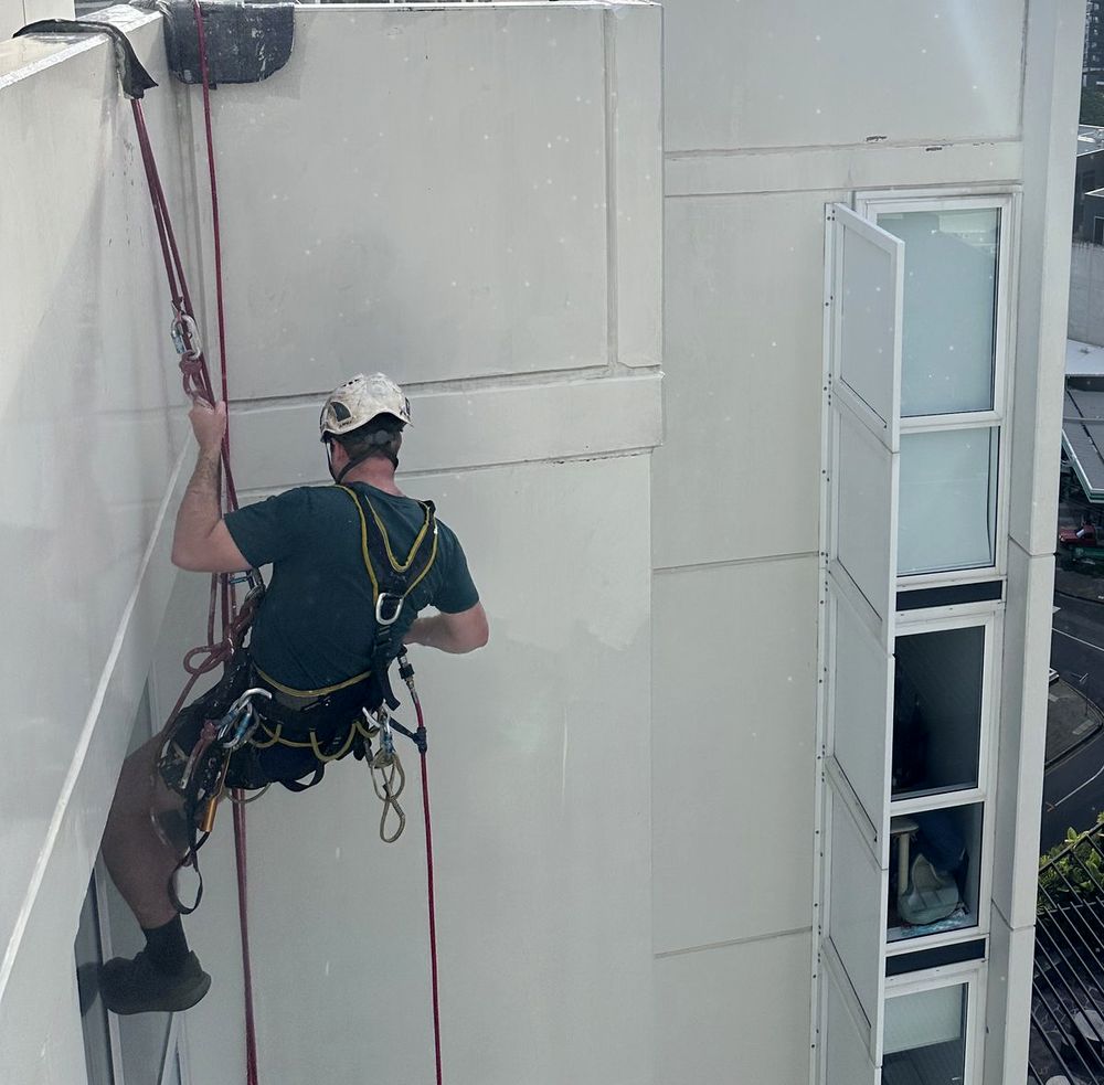 Hydro-Tec technician on rope access working on a high-rise facade