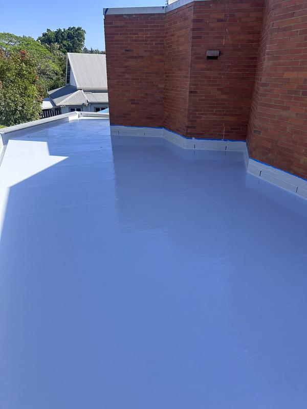 Rooftop waterproofing membrane against a brick wall