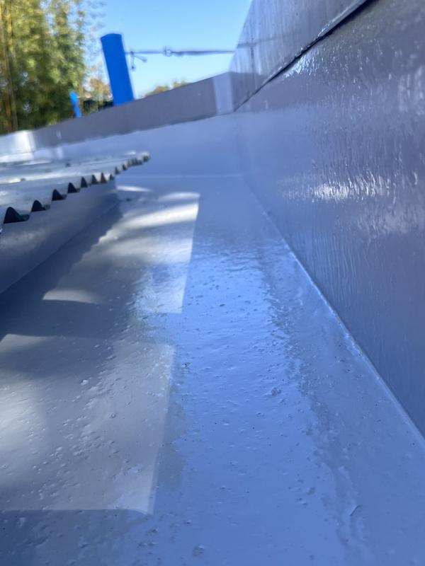 Membrane applied along a roof gutter and flashing