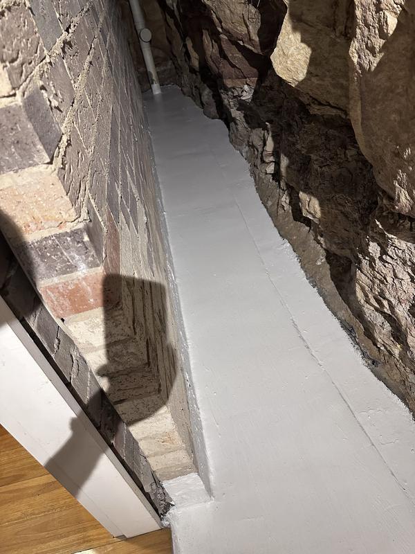 White membrane in a narrow passage beside a rock wall