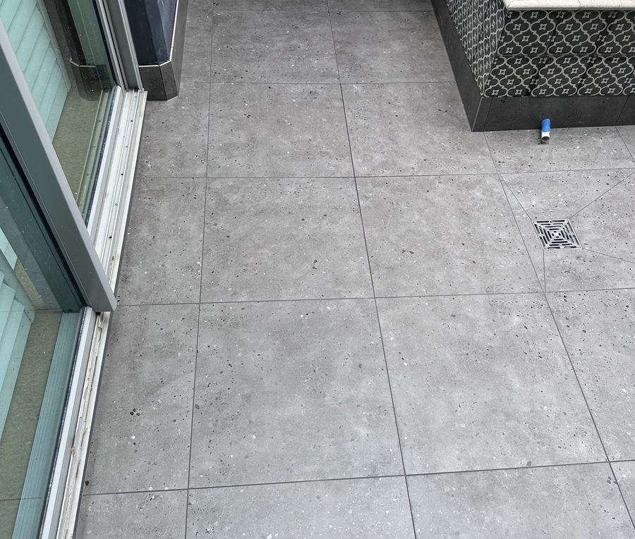 Restored apartment balcony with new tiles and floor waste