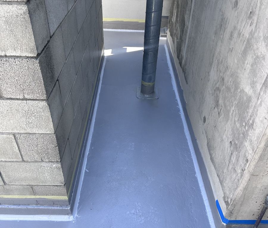 Freshly waterproofed walkway between commercial building walls